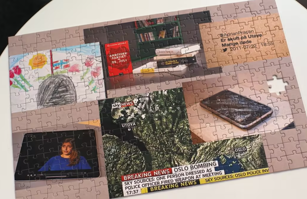 A puzzle with various images: a map, a broken mobile phone, an iPad with a portrait, a child's drawing, some books. Photo