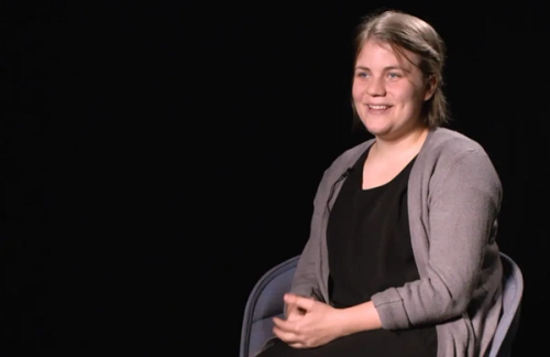 Image of sitting woman with black background.