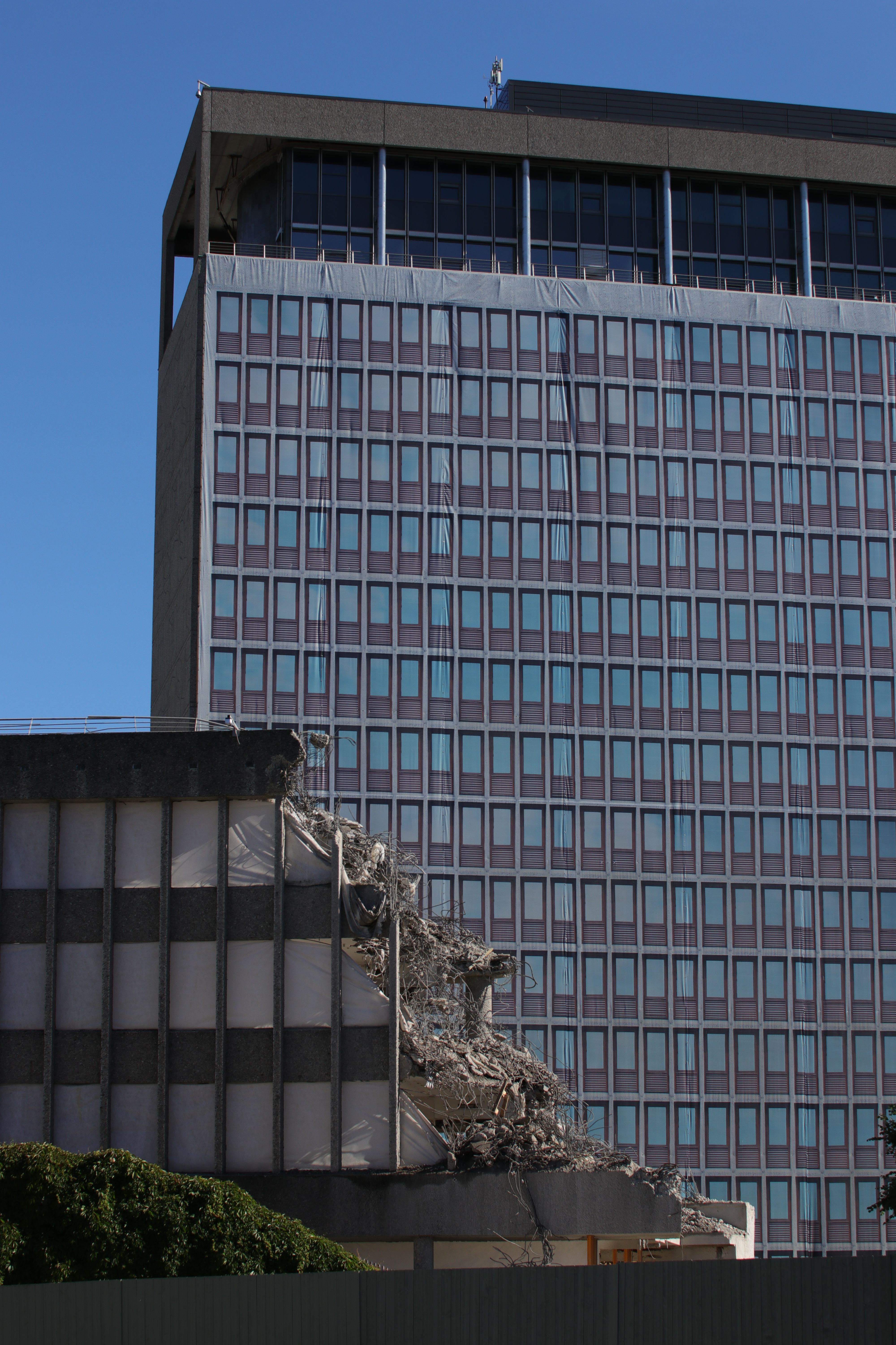  Building with damage to the front. Tall building with a covered facade. Blue sky.