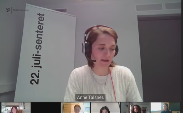 Screenshot of a webinar. A woman dressed in white with headsets. Beneath her are six smaller windows, each with a different woman.