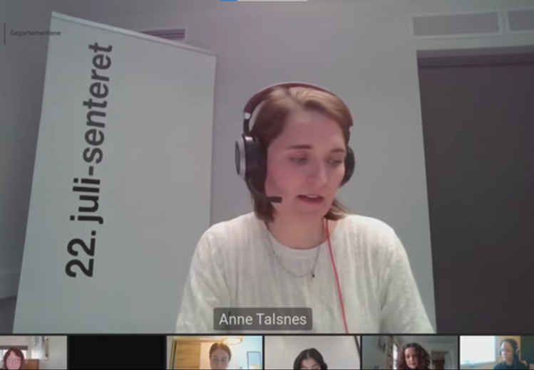 Screenshot of a webinar. A woman dressed in white with headsets. Beneath her are six smaller windows, each with a different woman.