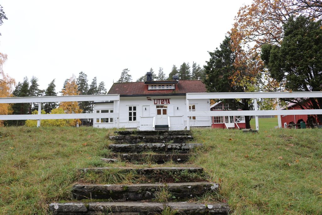 White house with a red sign with the text "Utøya". Stone stairs.