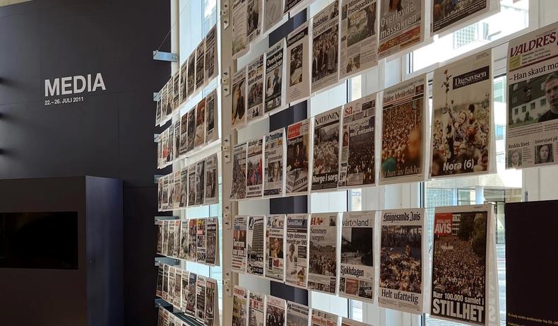 Multiple front pages exhibited in the 22 July Centre. Media is written in capital letters in the background.