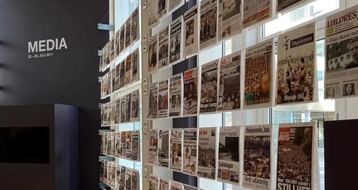 Multiple front pages exhibited in the 22 July Centre. Media is written in capital letters in the background.