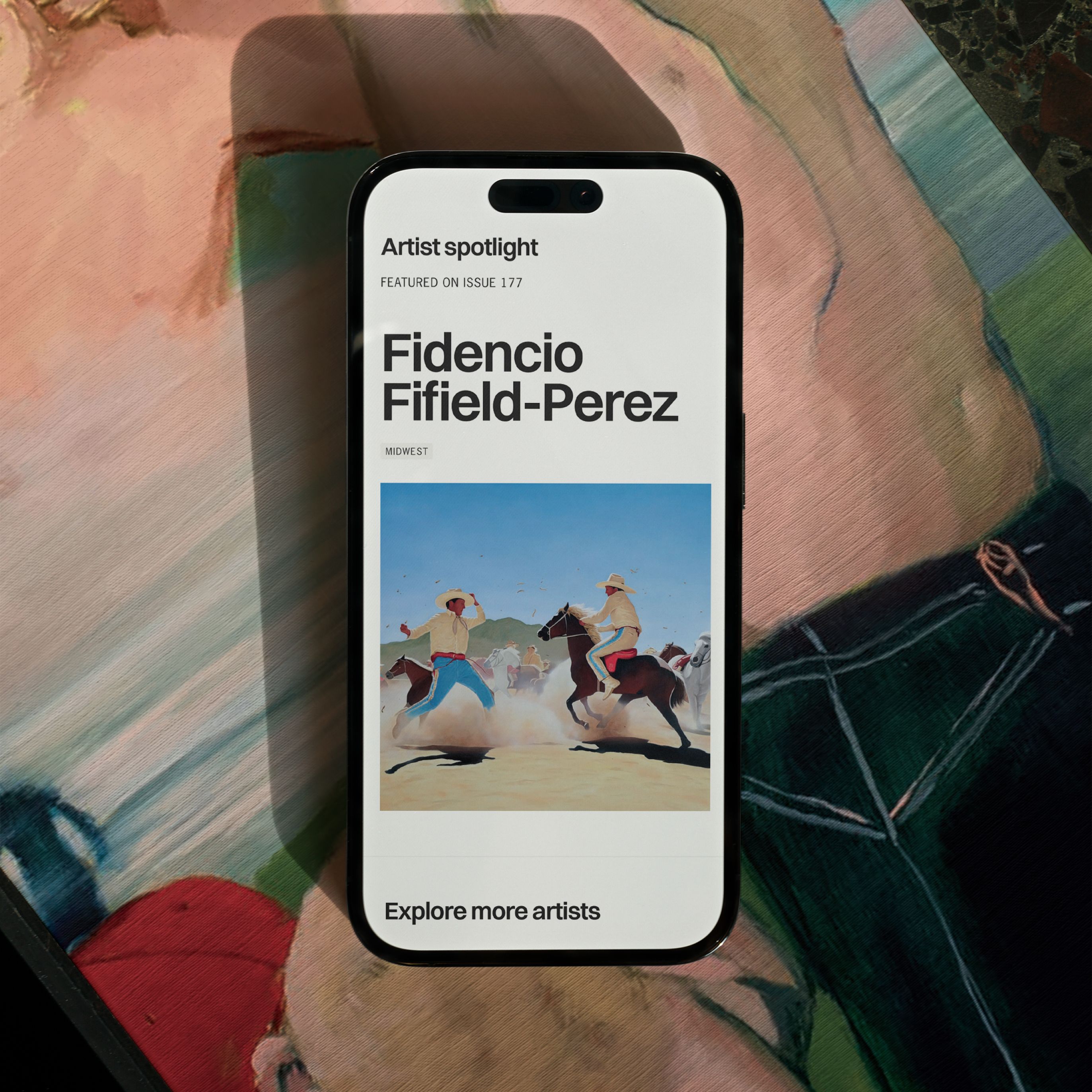 A smartphone displaying an artist spotlight for Fidencio Fifield-Perez, featuring a painting of two cowboys on horseback, placed on another painting of a human figure.