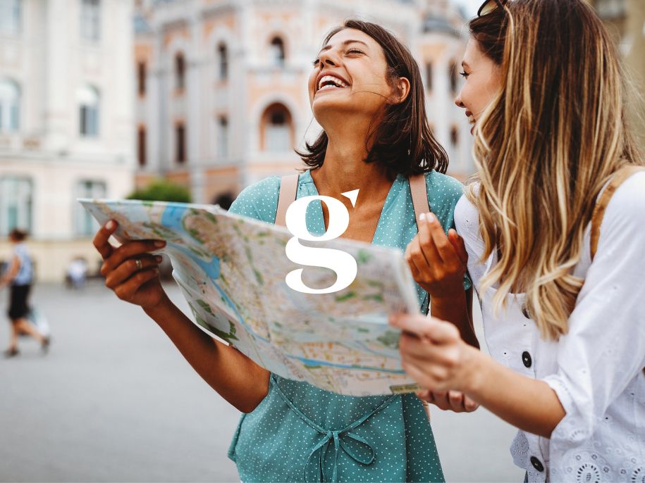 Two travellers laugh while reading a map