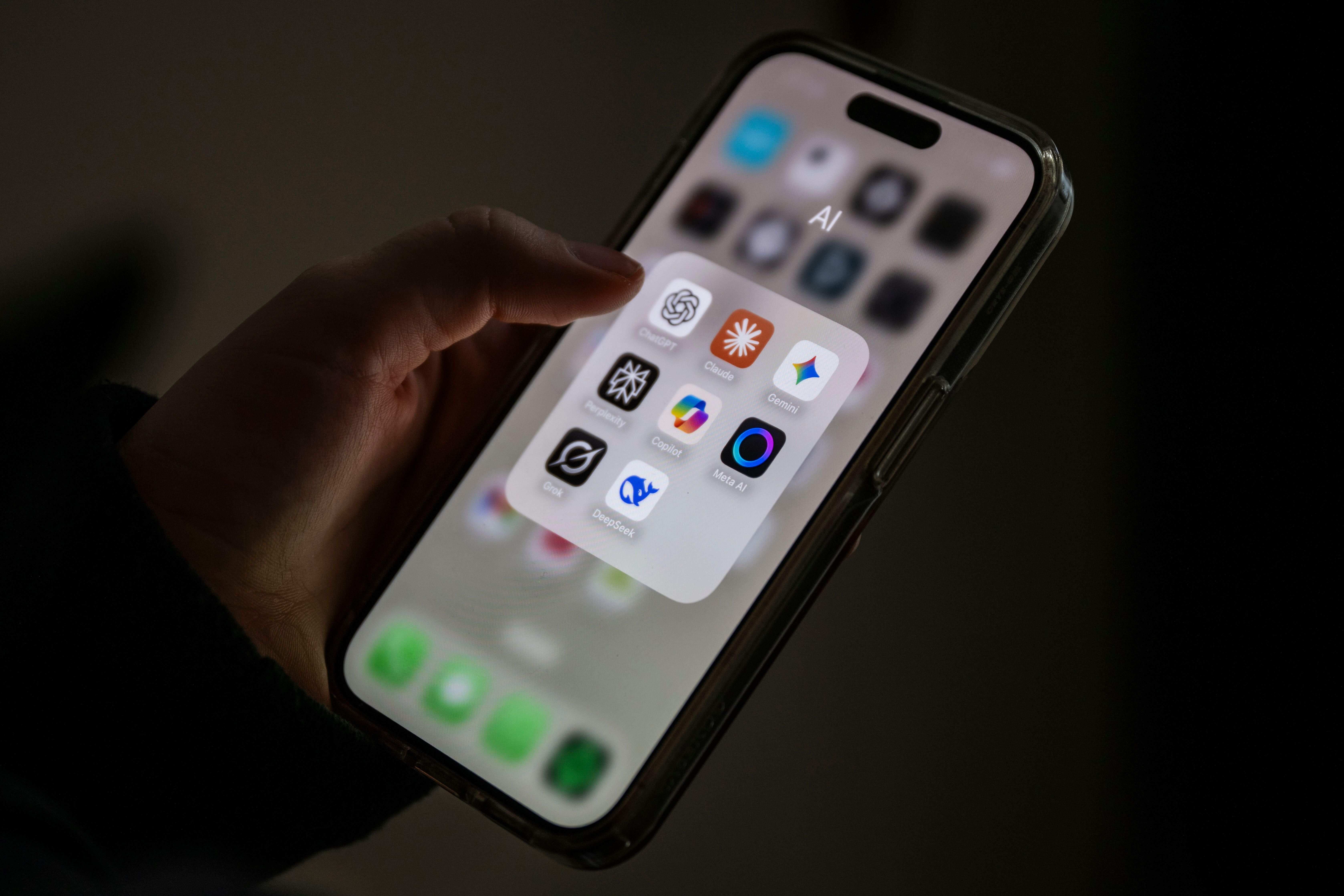 Several AI applications can be seen on a smartphone screen, including ChatGPT, Claude, Gemini, Perplexity, Microsoft Copilot, Meta AI, Grok and DeepSeek.