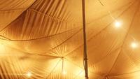 view from inside yellow tent with poles and lights