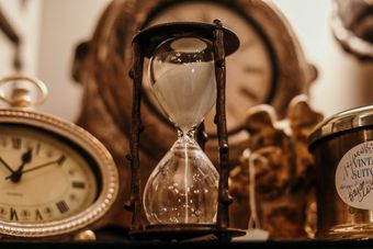 hourglass among maps and ancient clocks