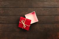 Small red gift box opened on wood table