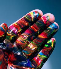 Human hand facing palm with swirled colors painted on it