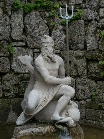Statue of Neptune with his trident against rocks