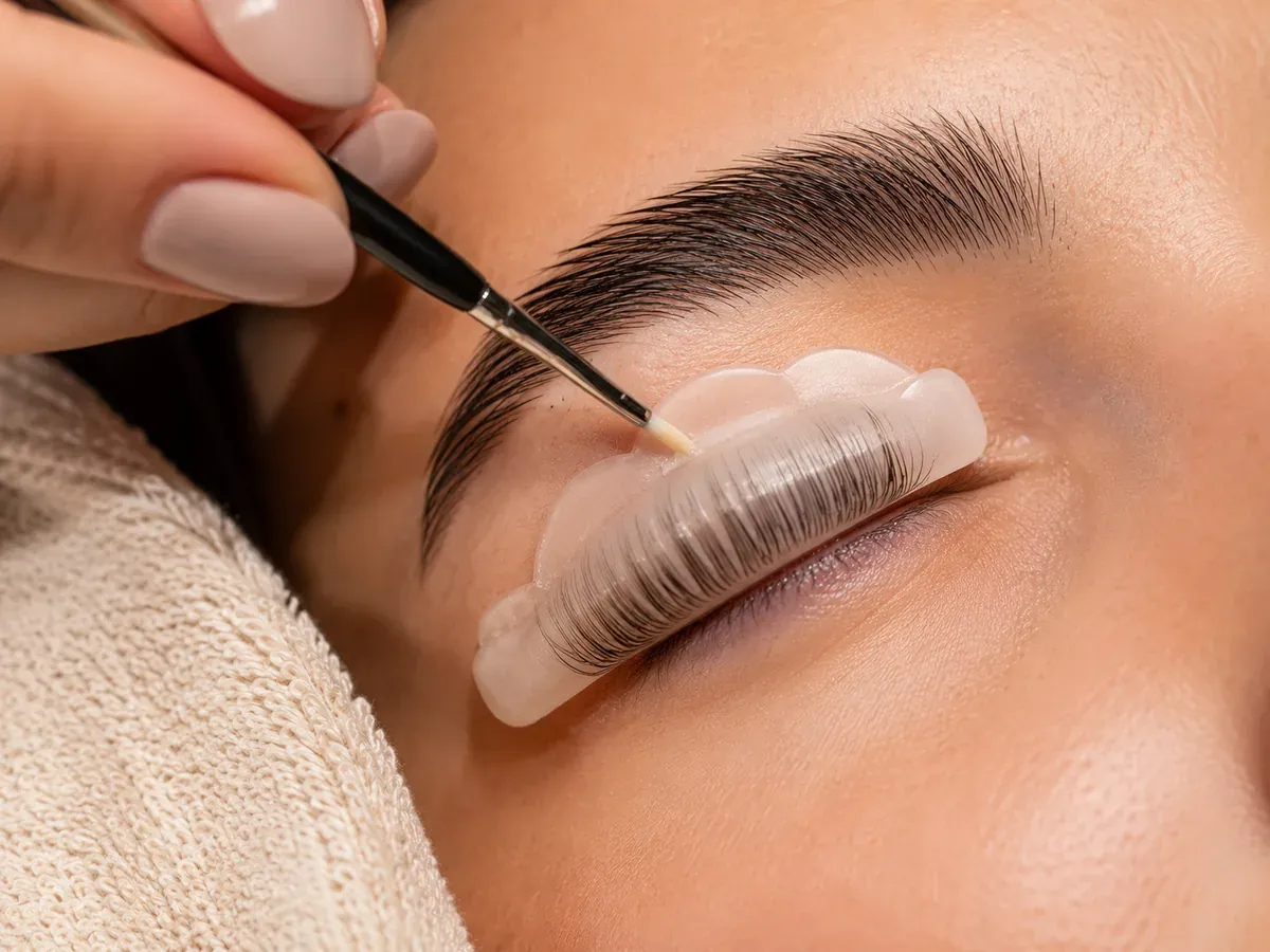 Lash lift and brow treatment close-up with a small brush near the eyebrow