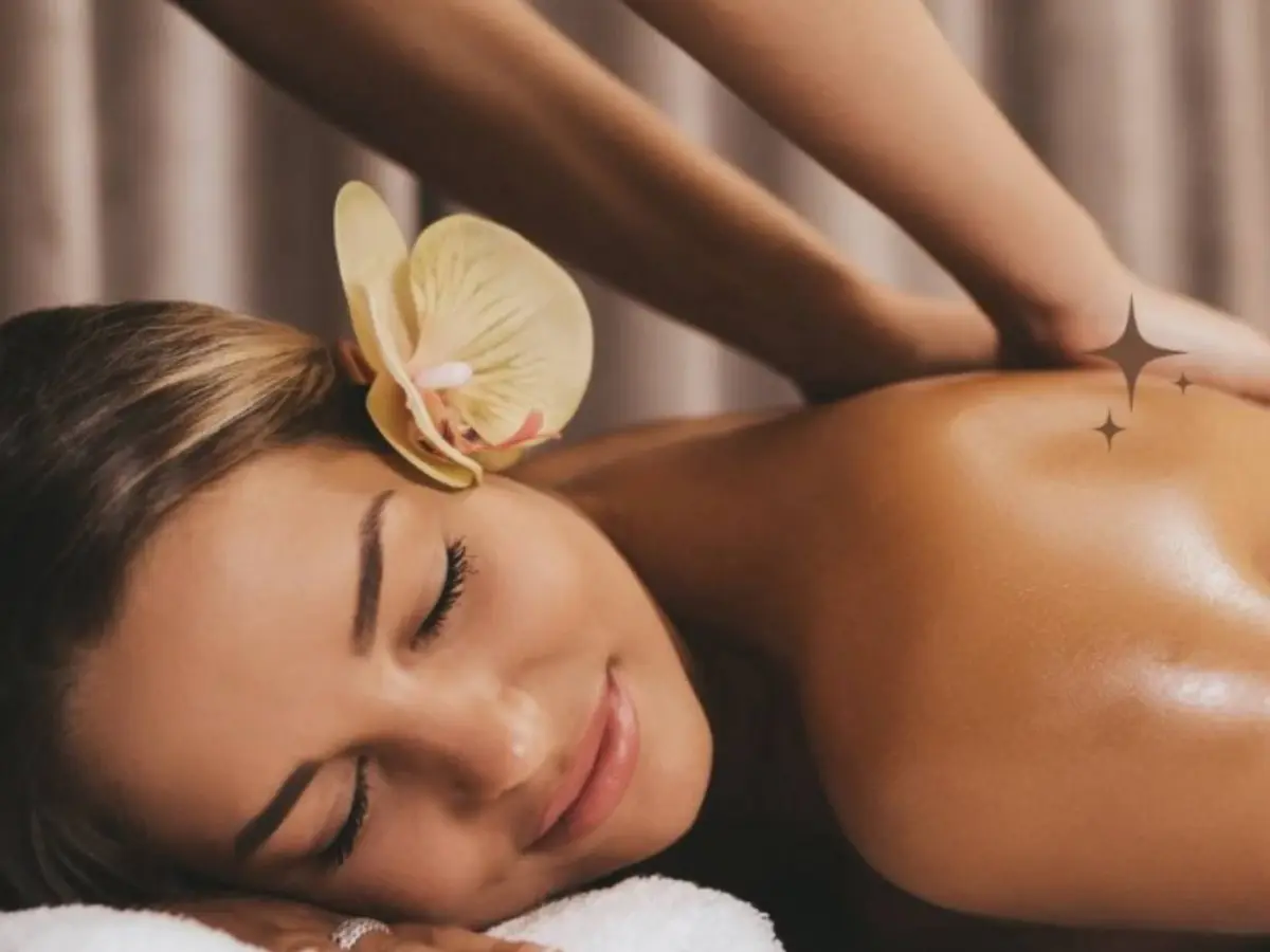Client relaxing during a massage with an orchid beside her face