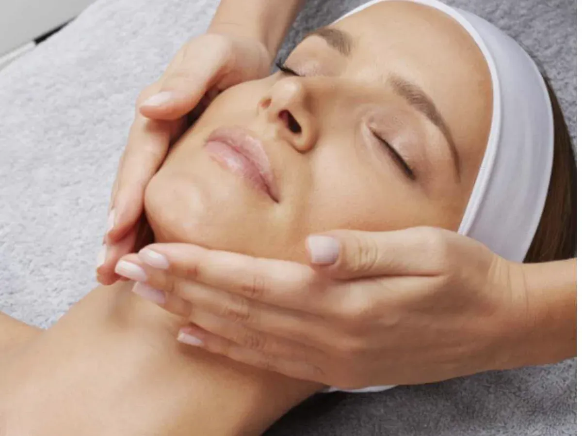 Client receiving a facial massage with hands supporting the face
