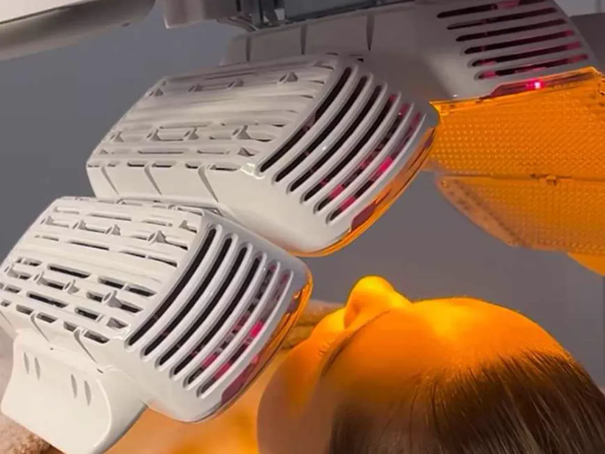 HEALITE II LED treatment lights positioned over a client during a facial treatment