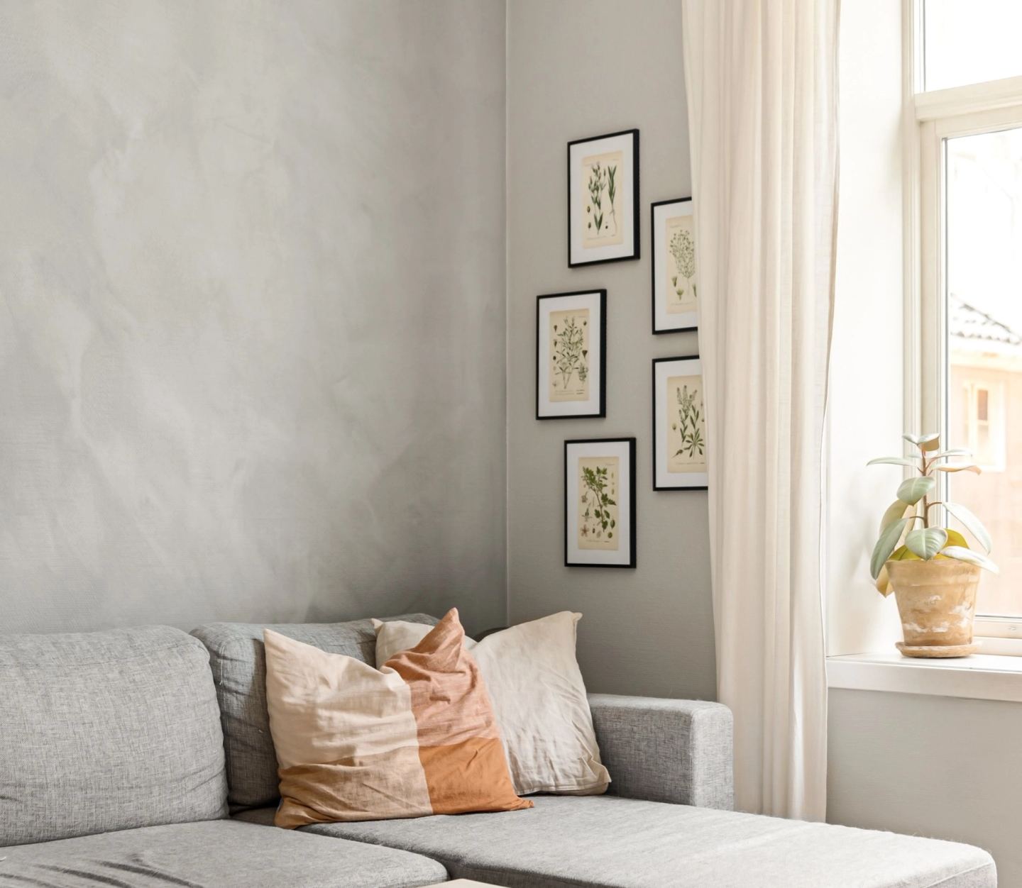 A cushioned window seat below framed prints, lit from the side