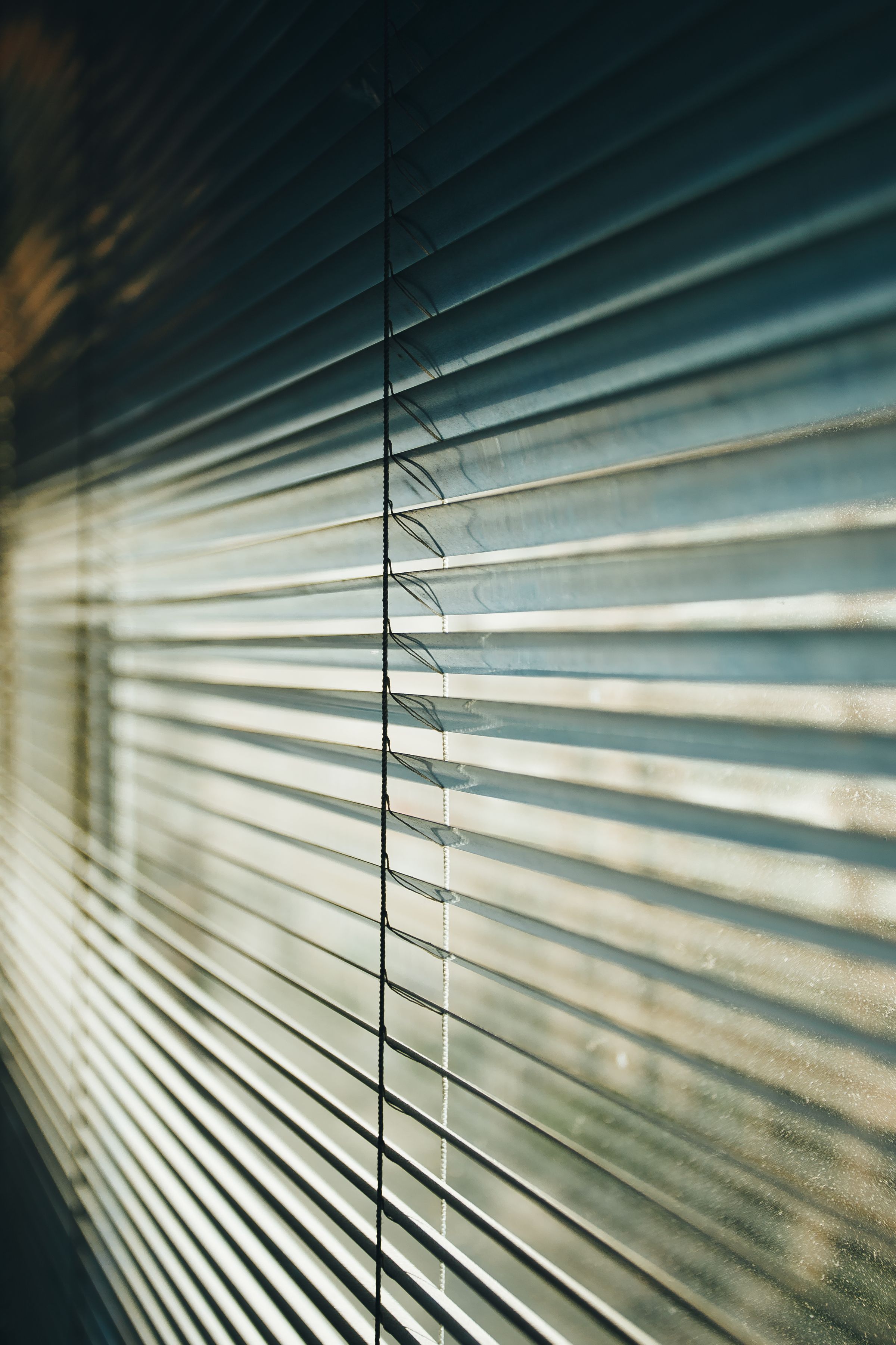 Close detail of blade edges and the tilt mechanism of a slatted blind