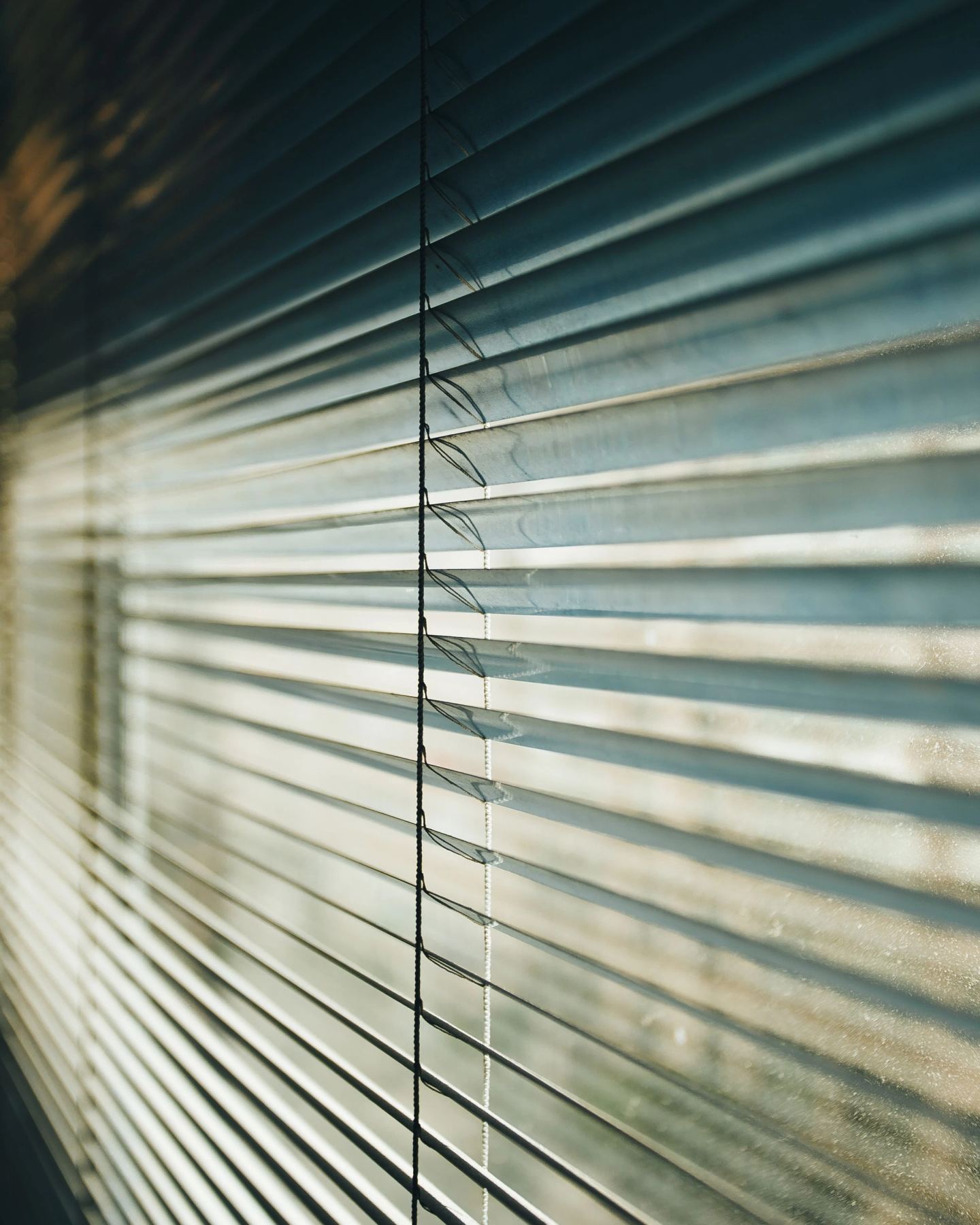 Close detail of blade edges and the tilt mechanism of a slatted blind