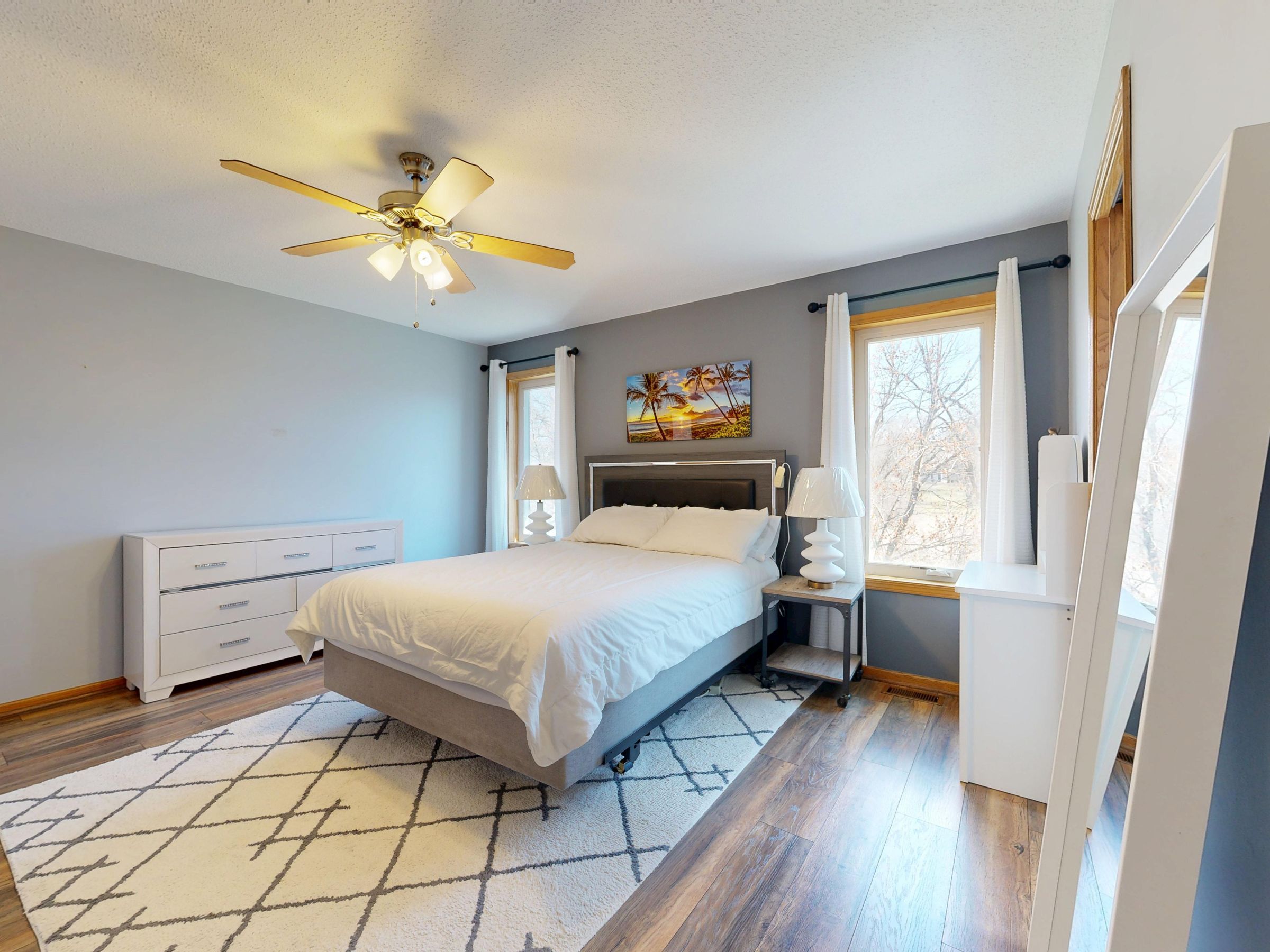 A bright bedroom with timber floors and generous windows