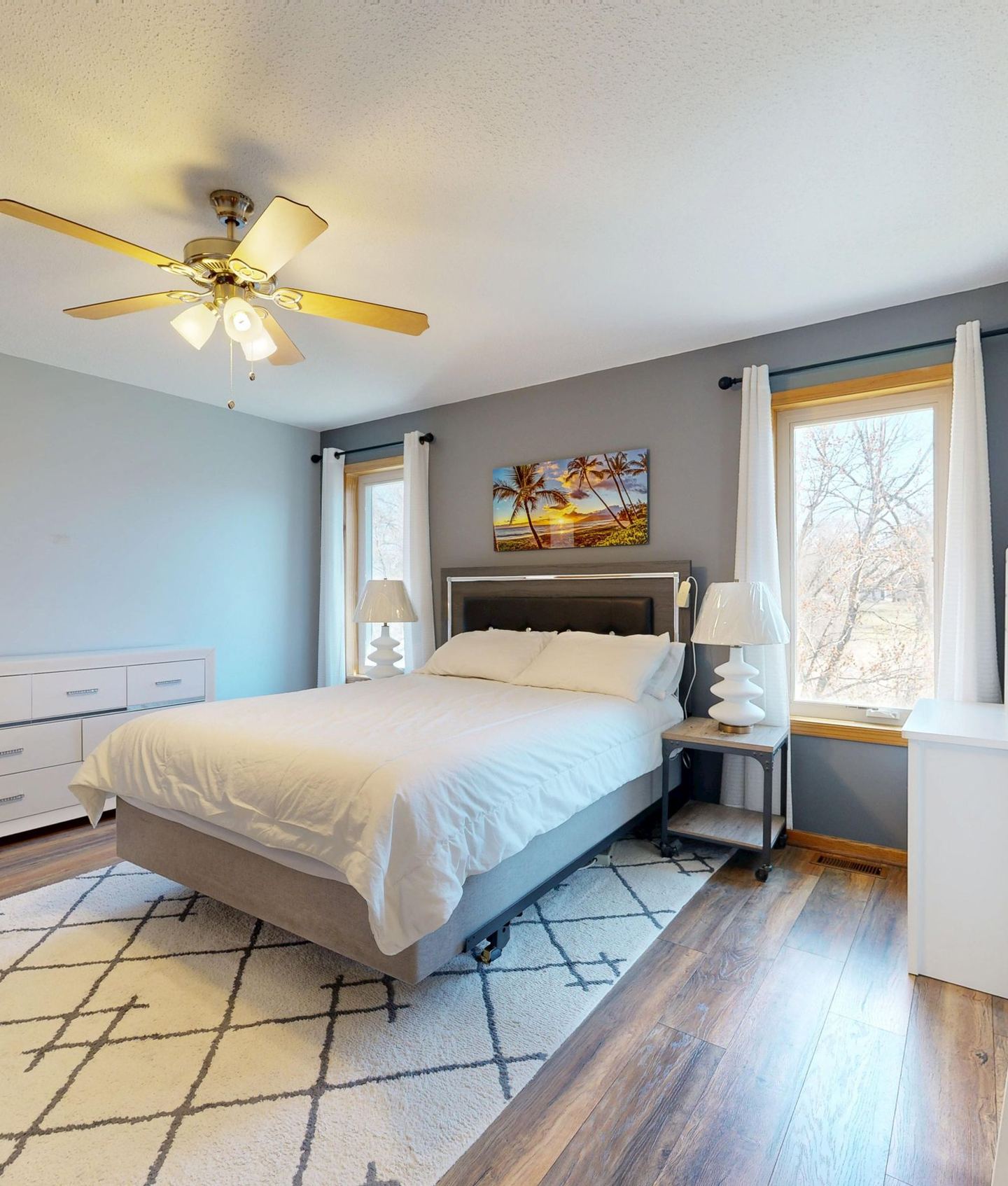 A bright bedroom with timber floors and generous windows
