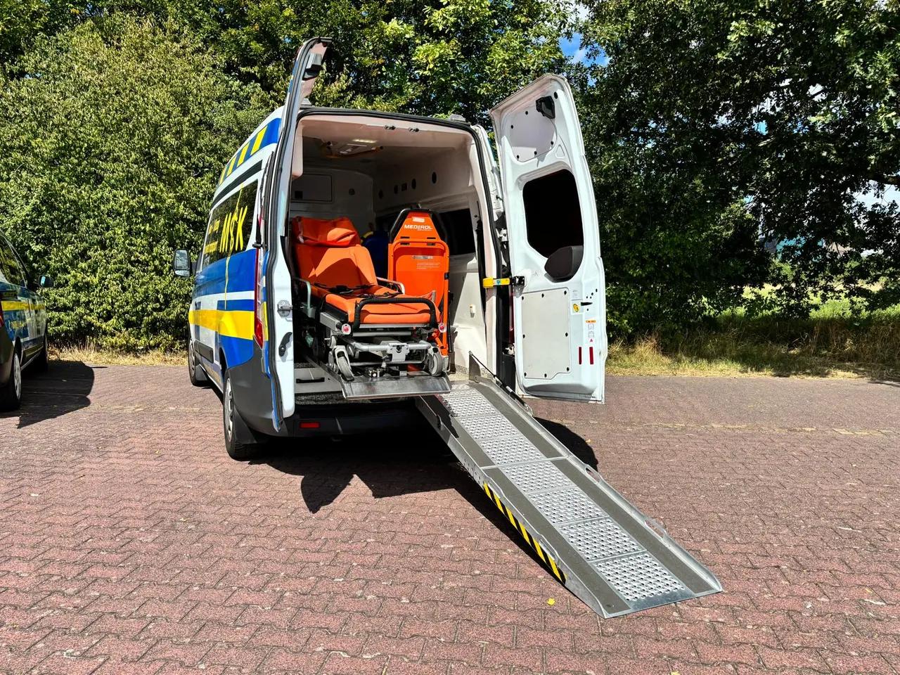 Geöffneter Krankentransporter mit ausgeklappter Rampe und Tragestuhl
