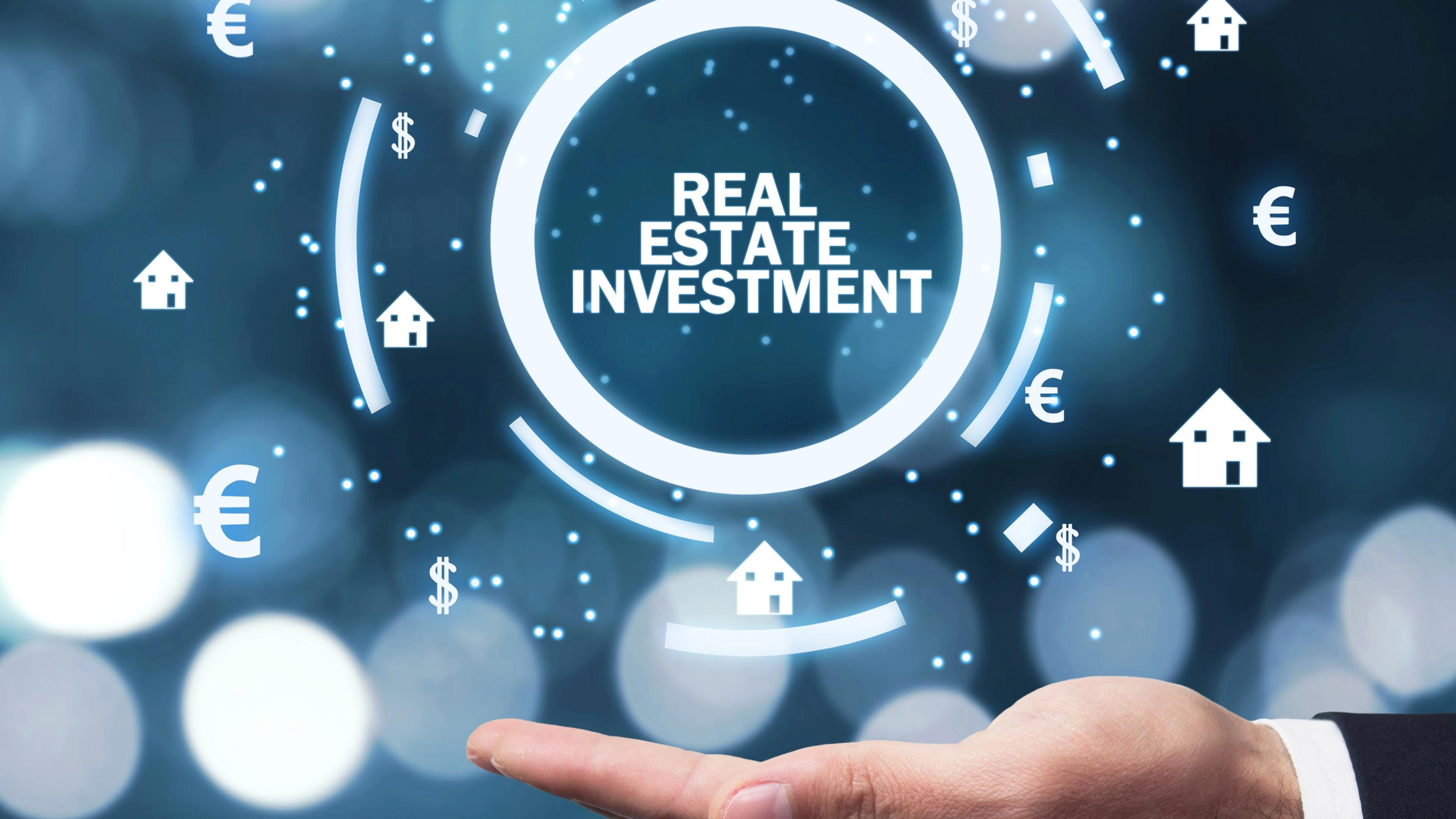 Hand mit Schriftzug: Real Estate Investment