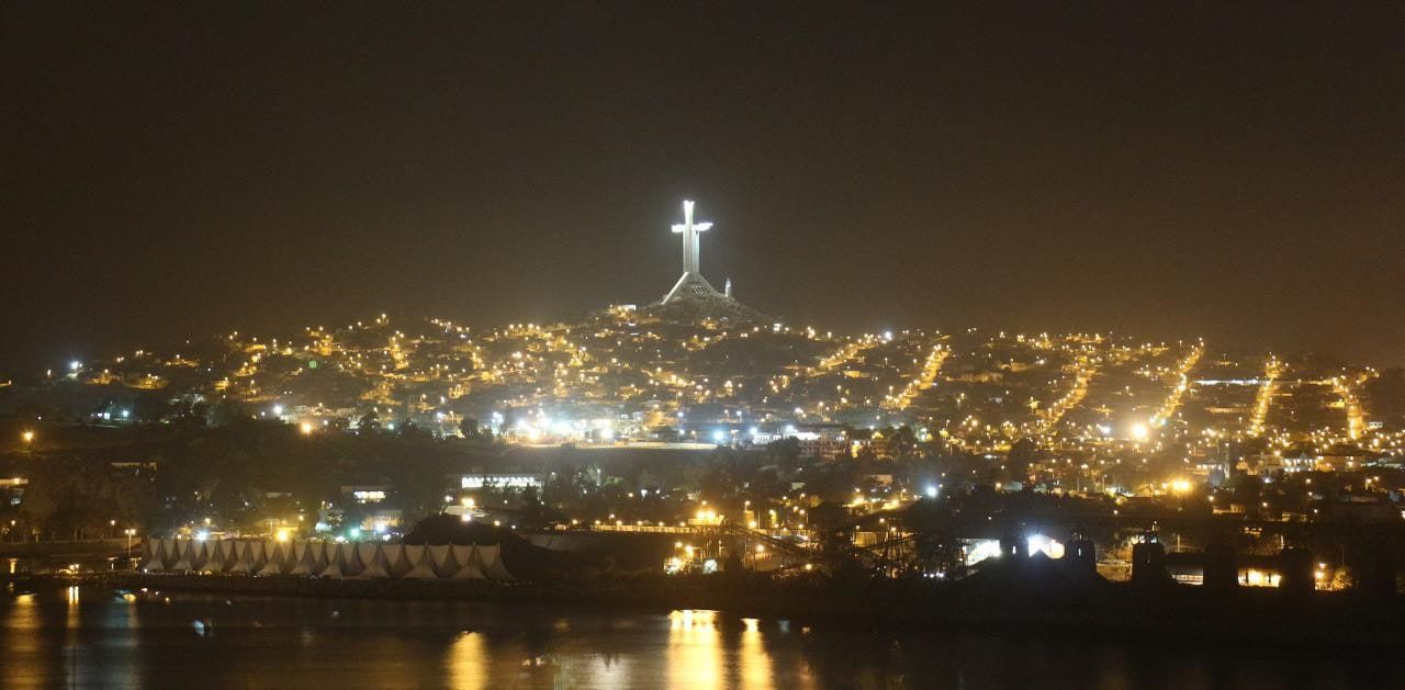 Vista panorámica nocturna de la bahía de La Herradura con la Cruz del Tercer Milenio iluminada.