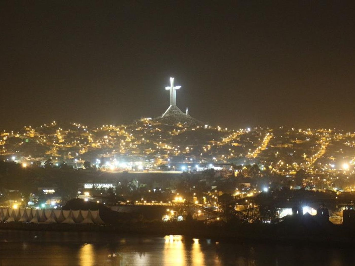 Vista panorámica nocturna de la bahía de La Herradura con la Cruz del Tercer Milenio iluminada.