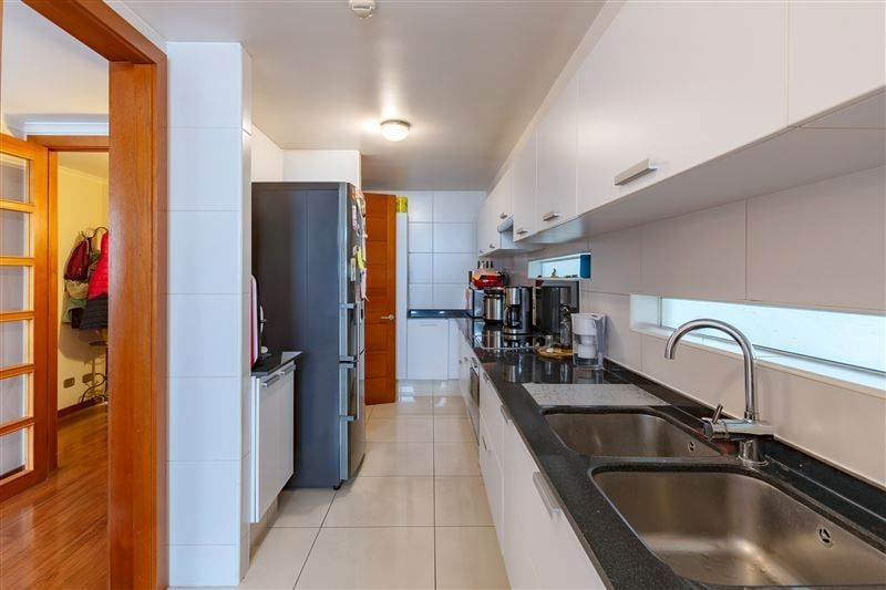 Cocina en línea con encimera de granito y paso a logia