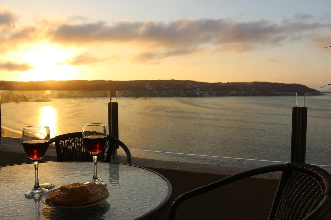 Atardecer dorado sobre la bahía de La Herradura desde la terraza privada del departamento.