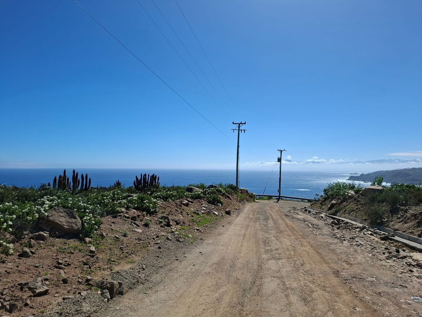 Panorámica hacia el mar desde el sector alto de la parcelación bajo sol radiante.