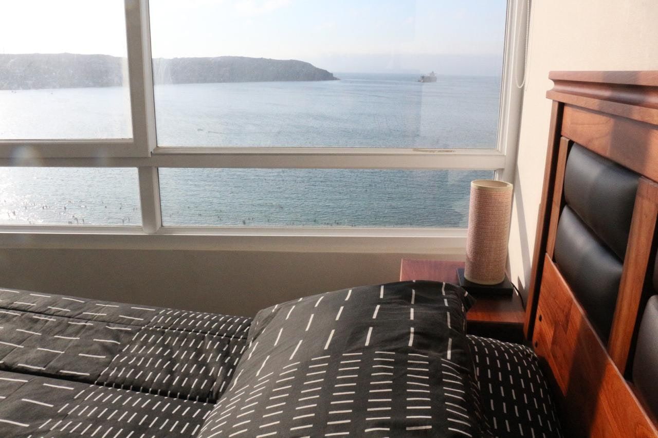 Ventanales esquineros del dormitorio principal con vista panorámica abierta a toda la bahía de La Herradura.