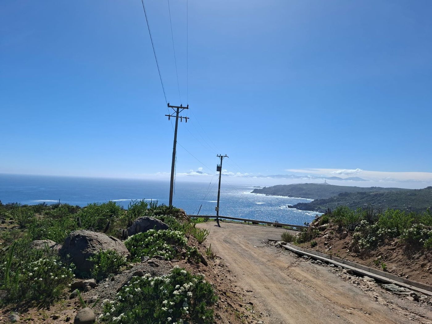 Camino de acceso con vista panorámica abierta a la bahía y costa de El Panul con sol radiante.