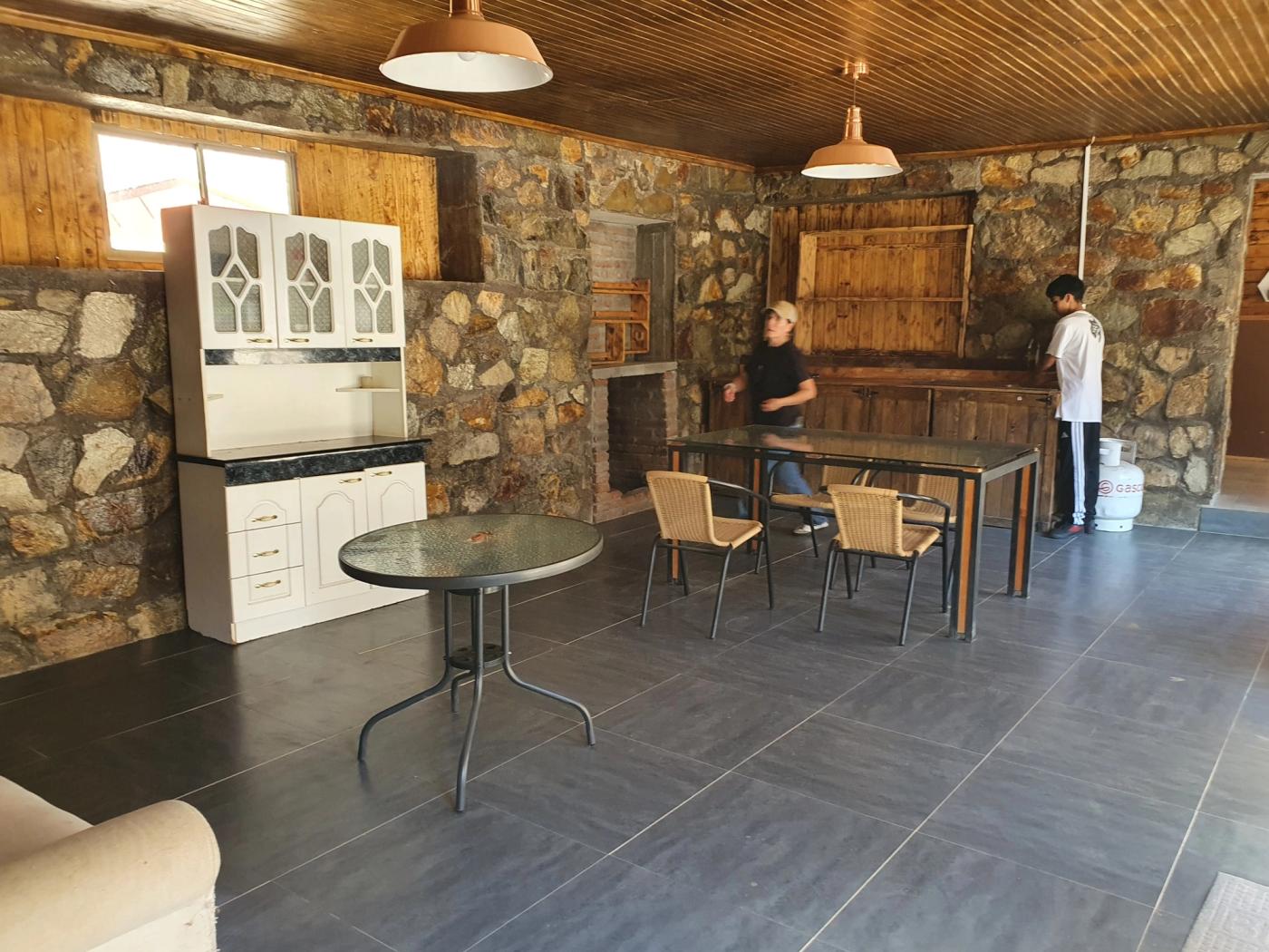 Sala comedor con bar de madera, mesas y sillas de mimbre