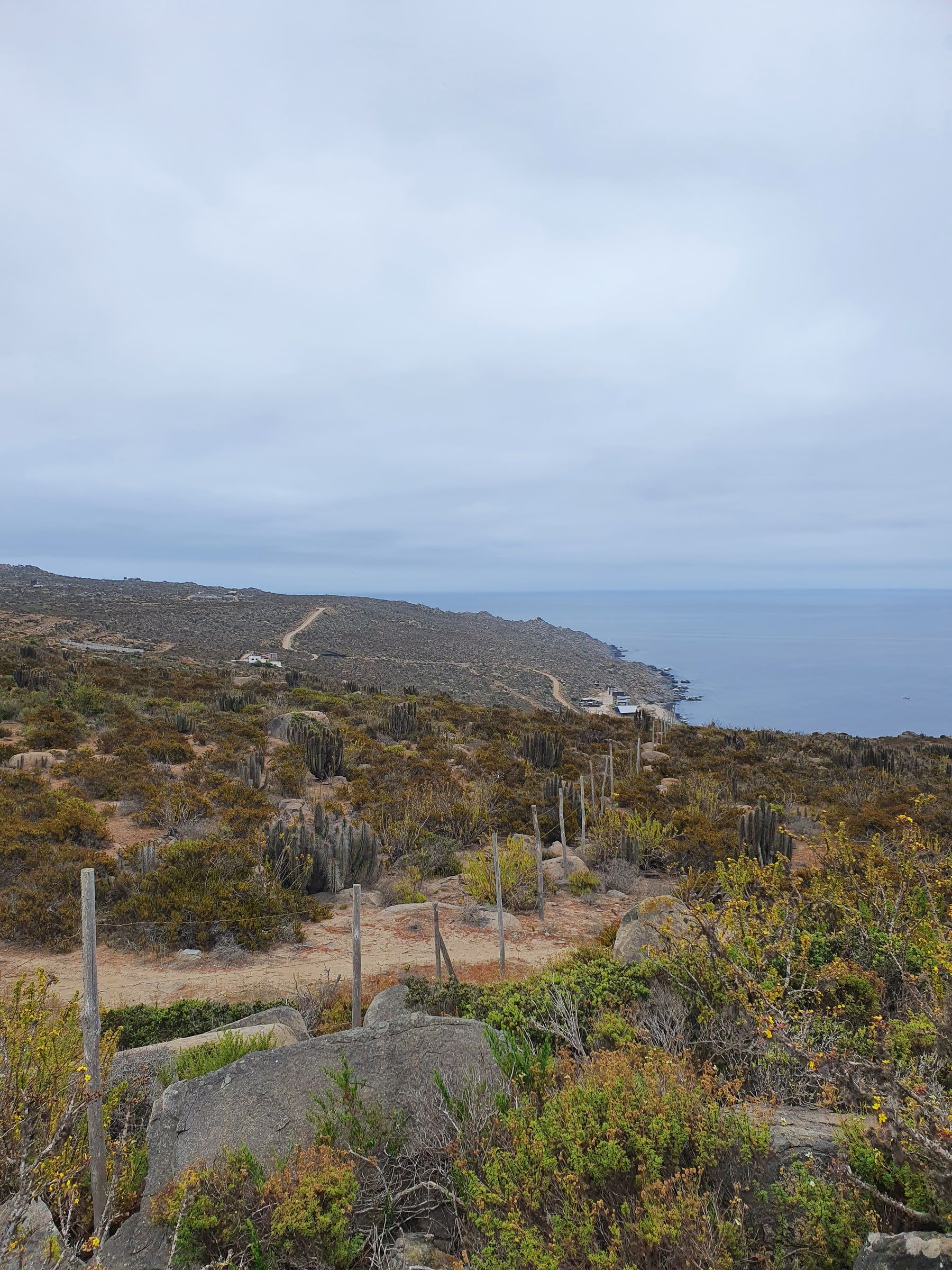 Terreno cercado en pendiente bajando hacia caleta y mar