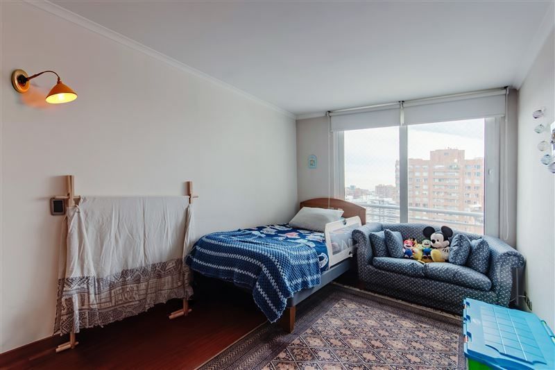 Dormitorio con cama individual, sofá y ventanal