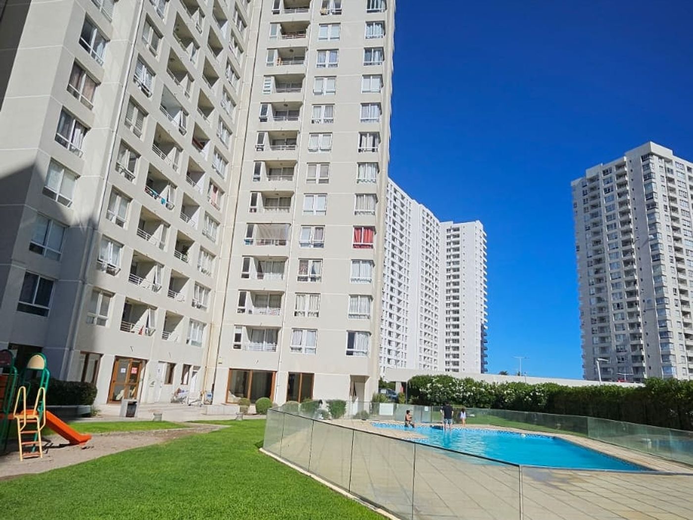Piscina y áreas verdes entre las torres del condominio