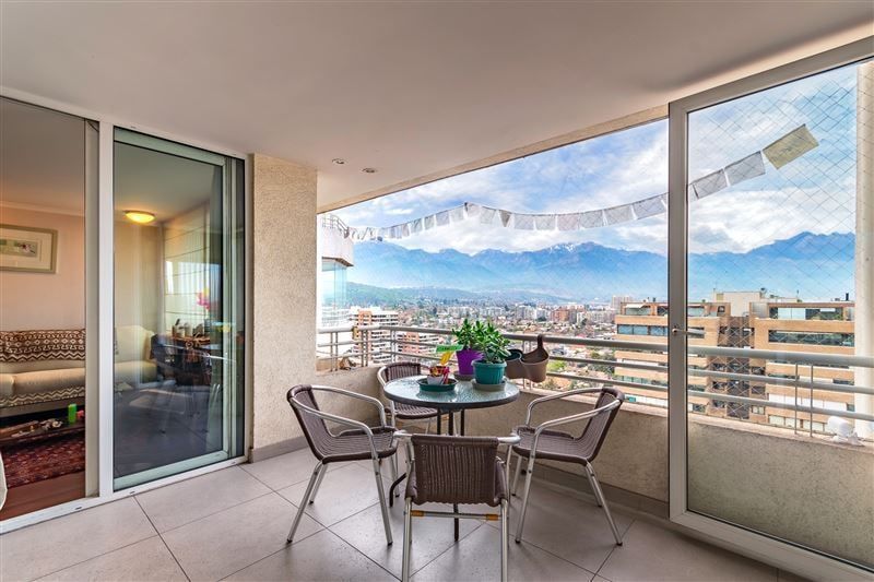 Balcón amplio con mesa, banderines y vista a la cordillera
