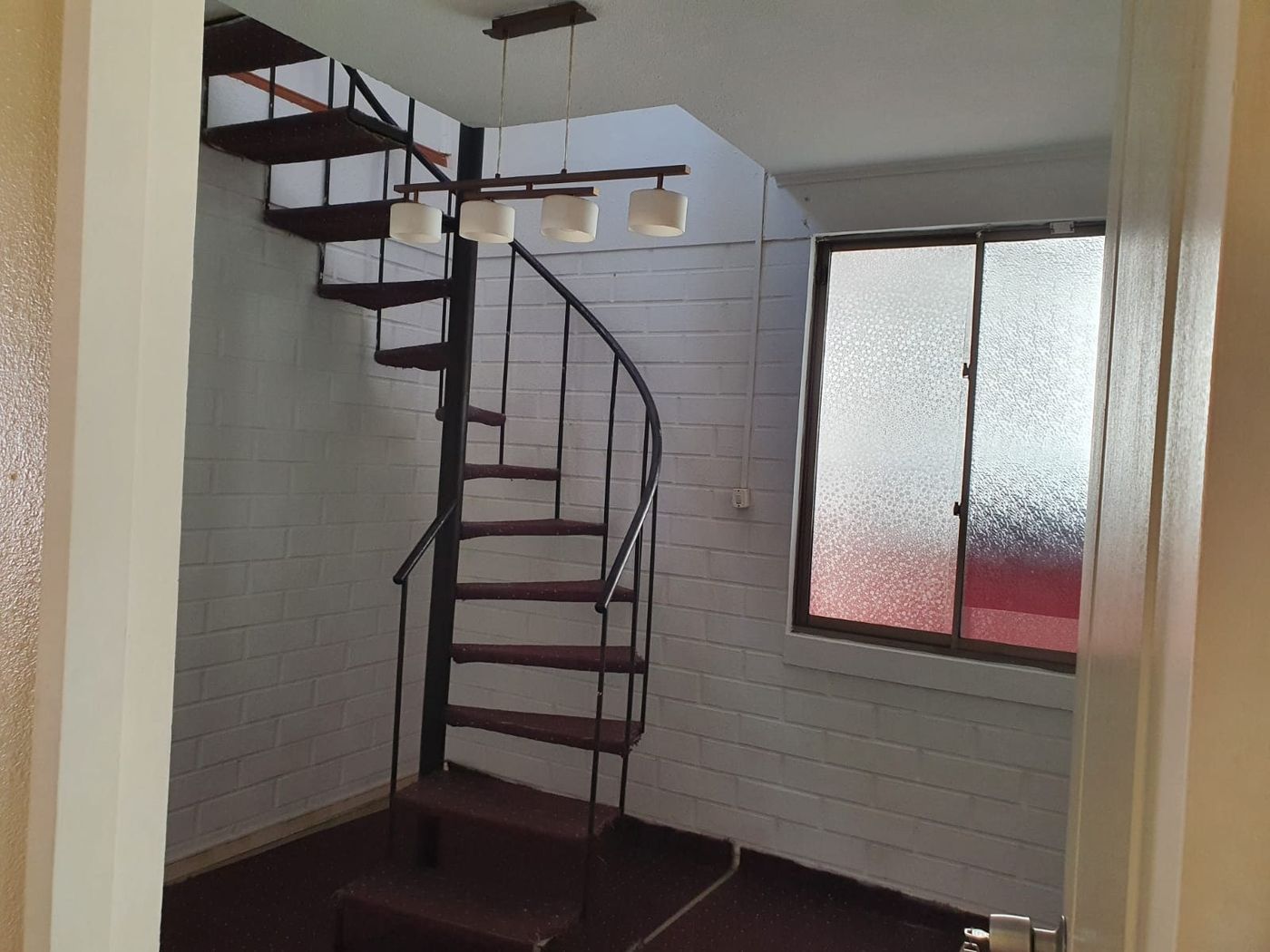 Escalera de caracol de fierro que conecta la planta baja con la mansarda del segundo piso.