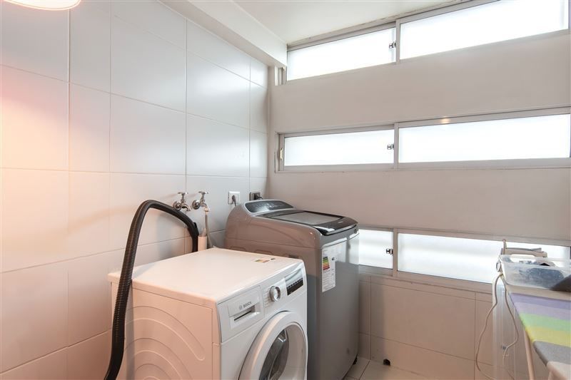 Logia con lavadora, secadora y ventanas altas