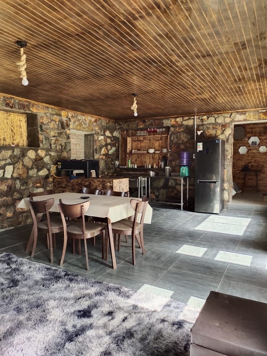 Comedor con mesa, refrigerador y cielo de madera