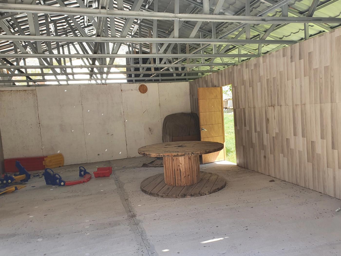 Galpón sin terminar con carrete de madera y juguetes
