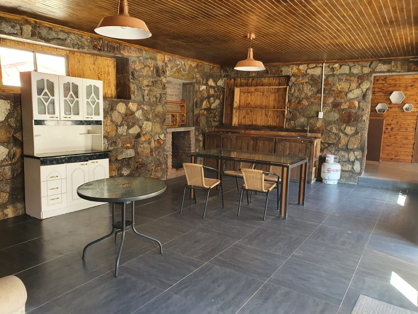 Sala comedor con bar de madera y mueble blanco de cocina