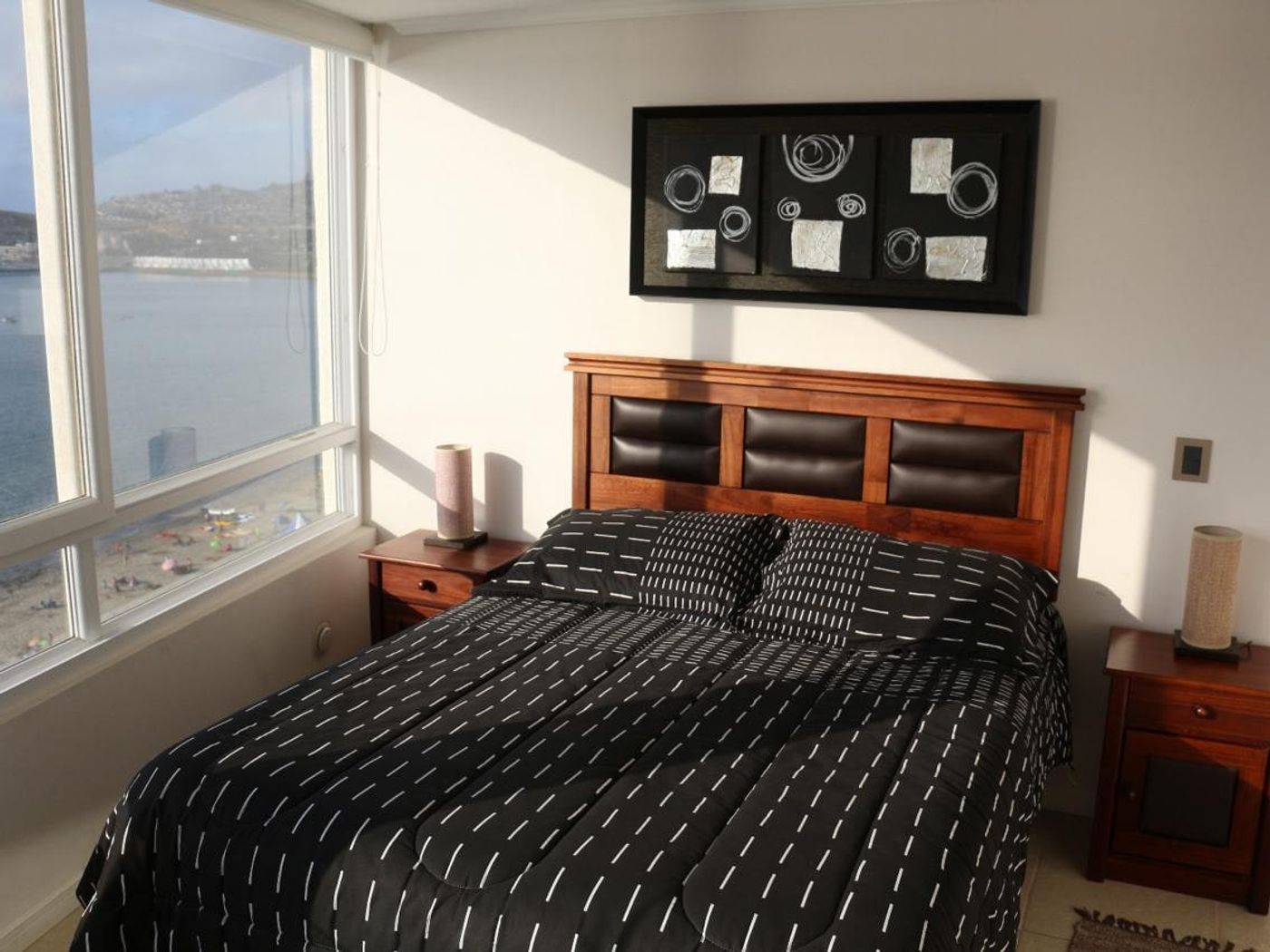 Dormitorio principal con cama matrimonial y amplio ventanal con vista despejada a la bahía.