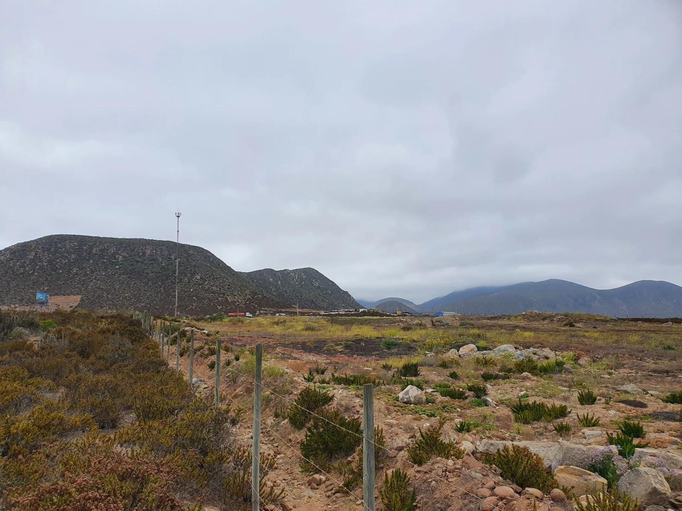 Mismo cerco con cerro y cordón montañoso al fondo