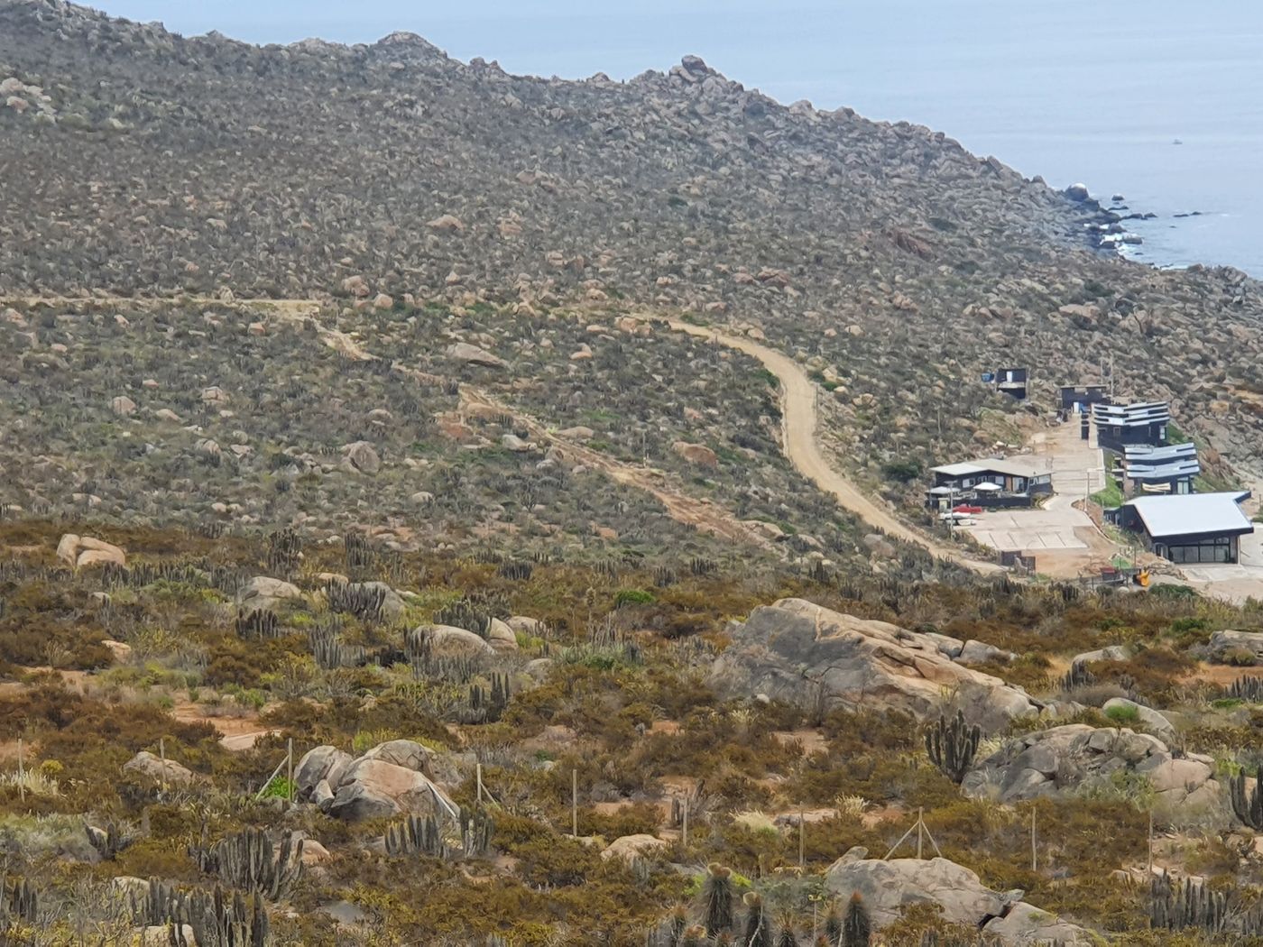 Camino de tierra serpenteando por el cerro hasta la caleta