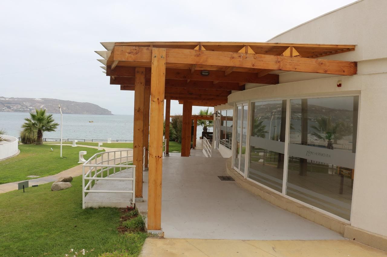 Mirador común exterior con pérgola de madera frente al mar y vista a la playa La Herradura.