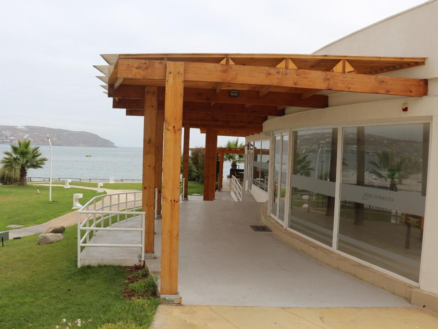 Mirador común exterior con pérgola de madera frente al mar y vista a la playa La Herradura.