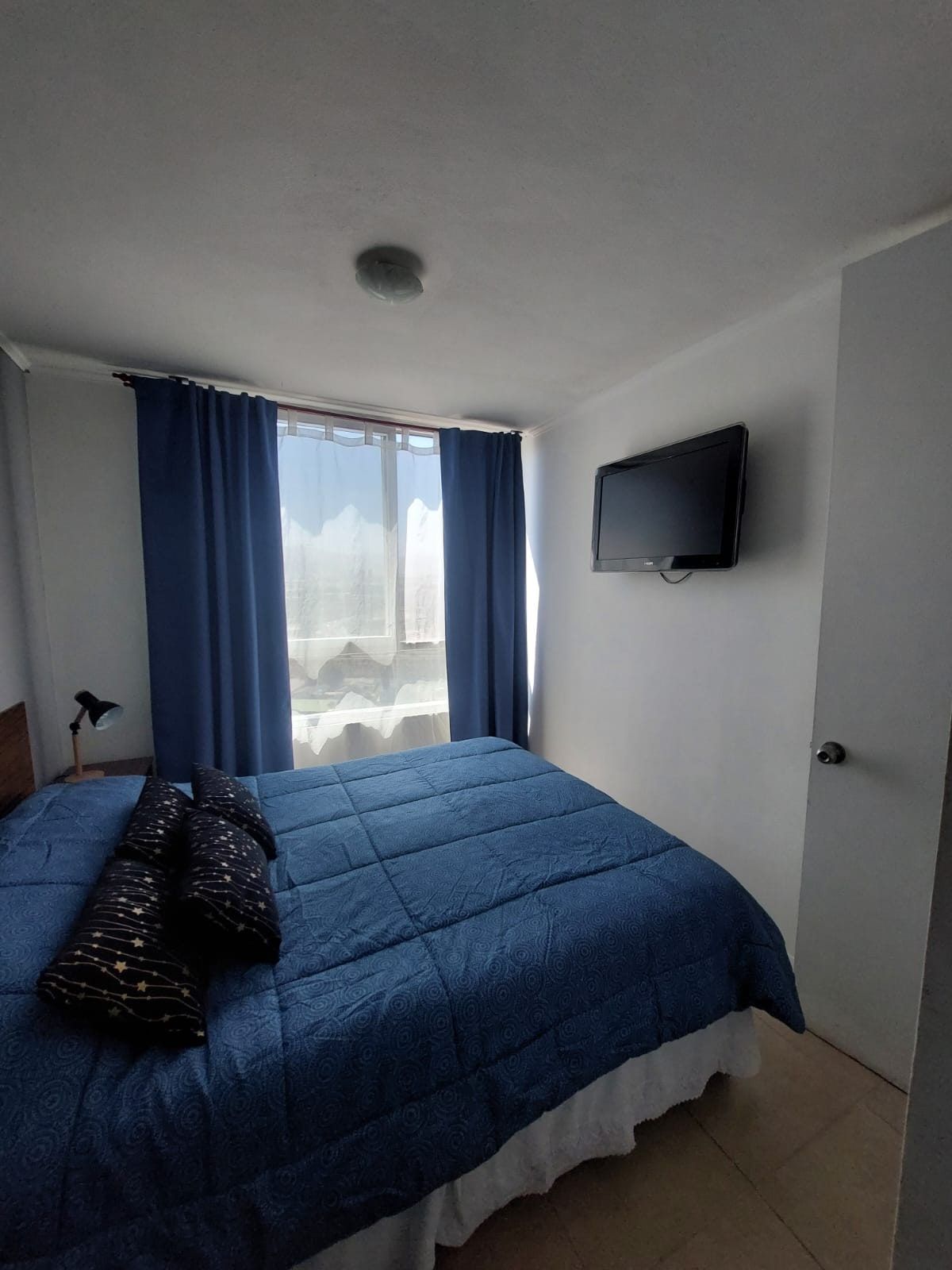 Dormitorio principal con ventanal y cortinas
